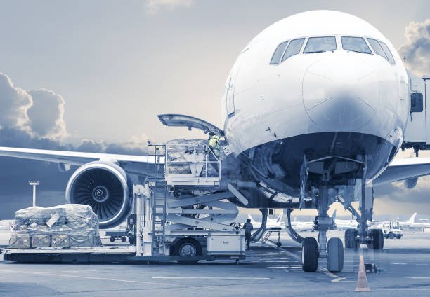 A white cargo aircraft being loaded before take off
